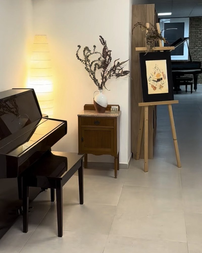 Aula de l'Escola de Música Cristina Blasi amb un piano vertical i un piano de cua al fons