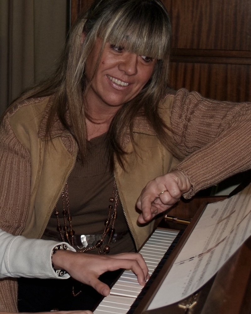 La Cristina Blasi acompanyant una alumna al piano en una fotografia d'arxiu